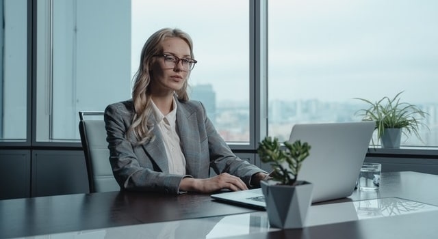 Businesswoman at desk working with laptop in office